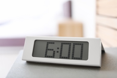 Digital alarm clock on table. Time to wake up