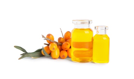 Photo of Natural sea buckthorn oil and fresh berries on white background