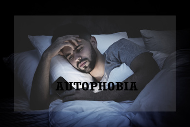 Image of Depressed young man with smartphone in bed at night. Autophobia - fear of isolation