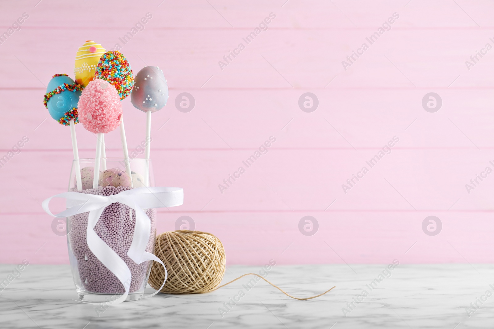 Photo of Delicious sweet cake pops on marble table, space for text. Easter holiday