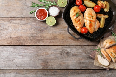 Flat lay composition with fried chicken breasts and space for text on wooden background