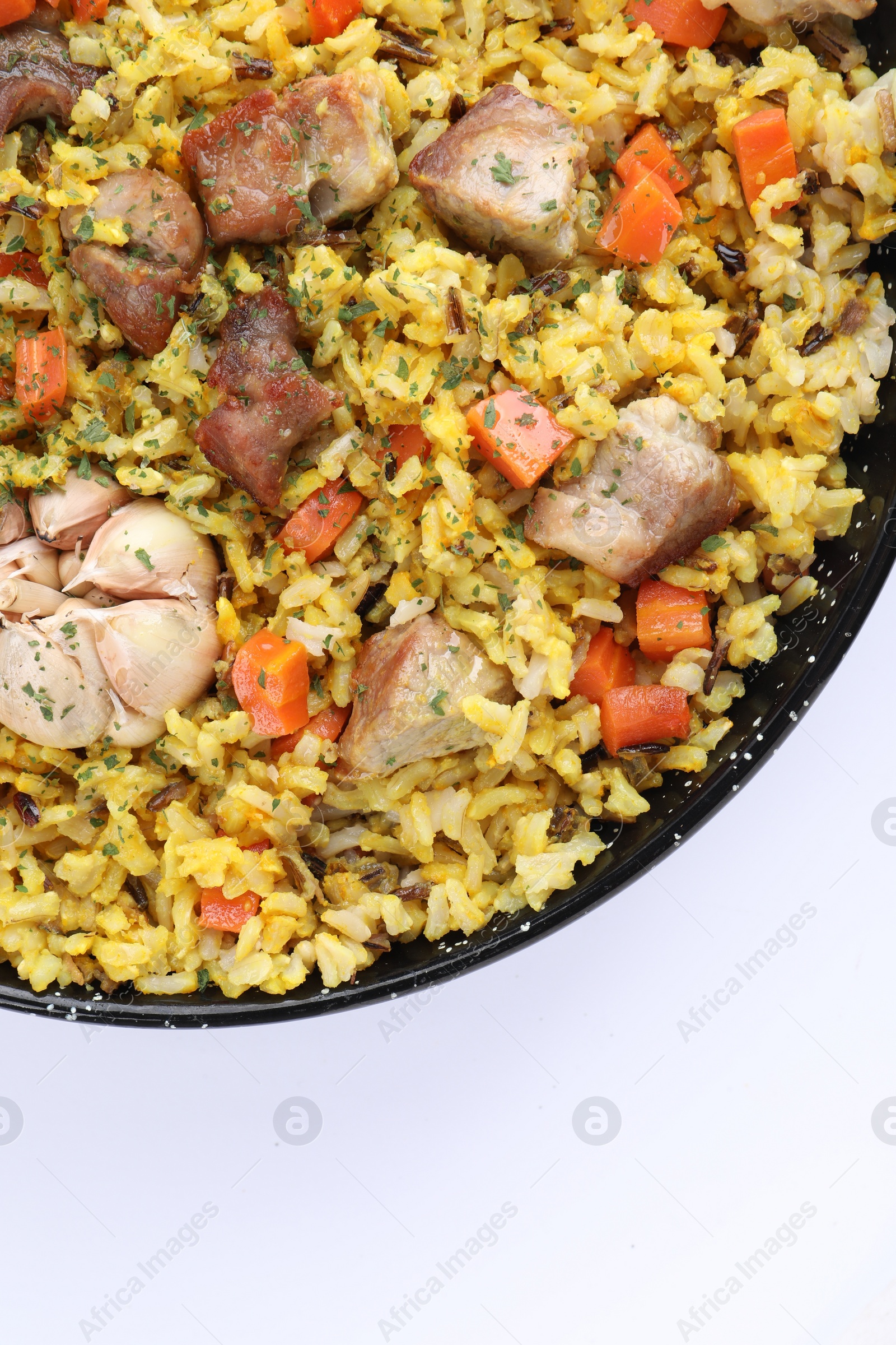 Photo of Delicious pilaf with meat, carrot and garlic on white background, top view