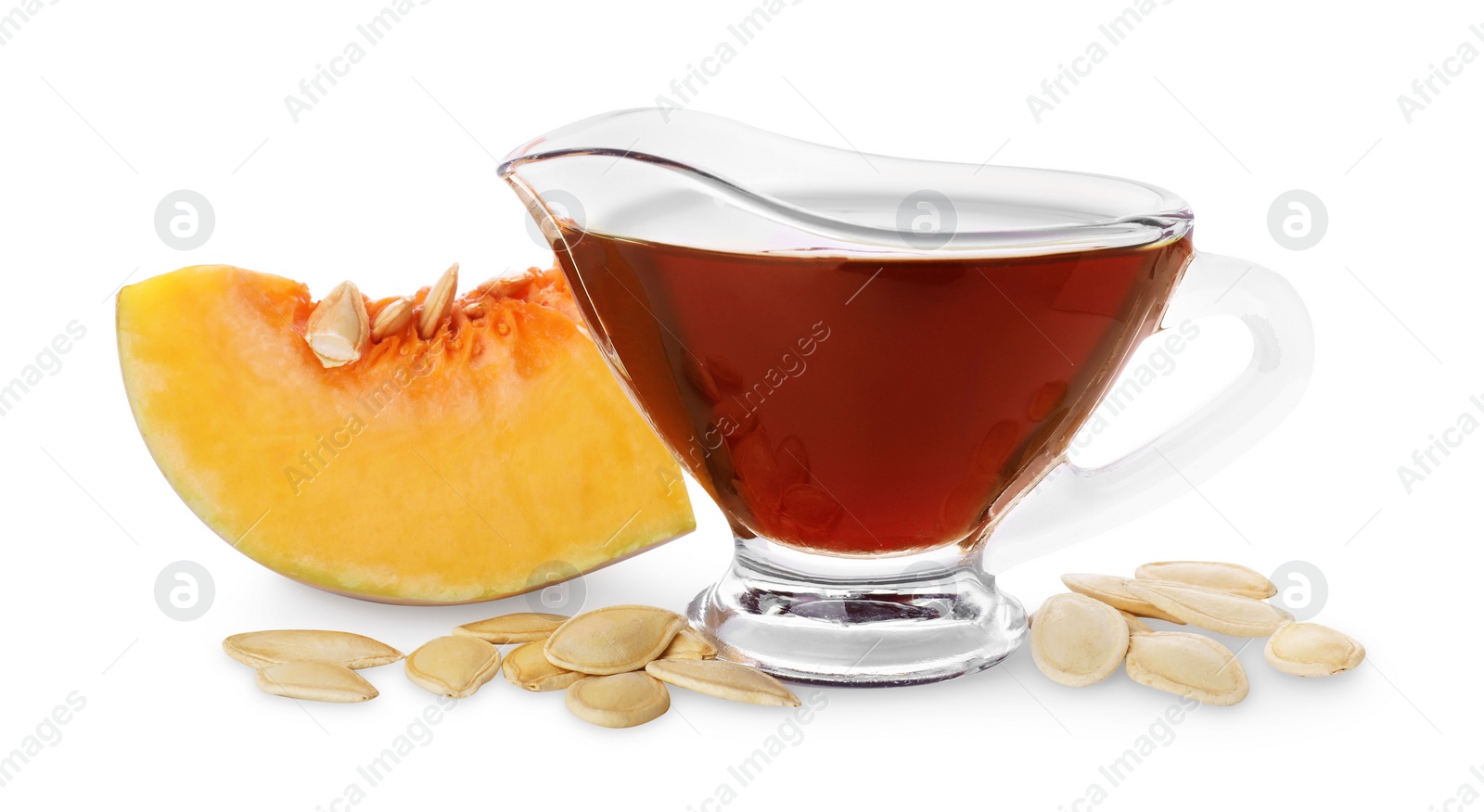 Photo of Fresh pumpkin seed oil in glass sauceboat isolated on white