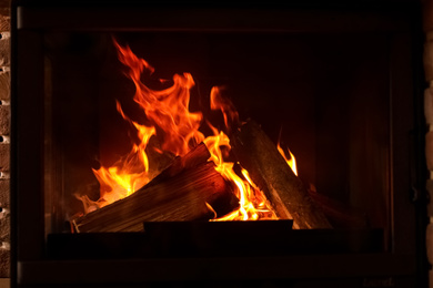 Photo of Fireplace with burning wood, closeup view. Winter vacation