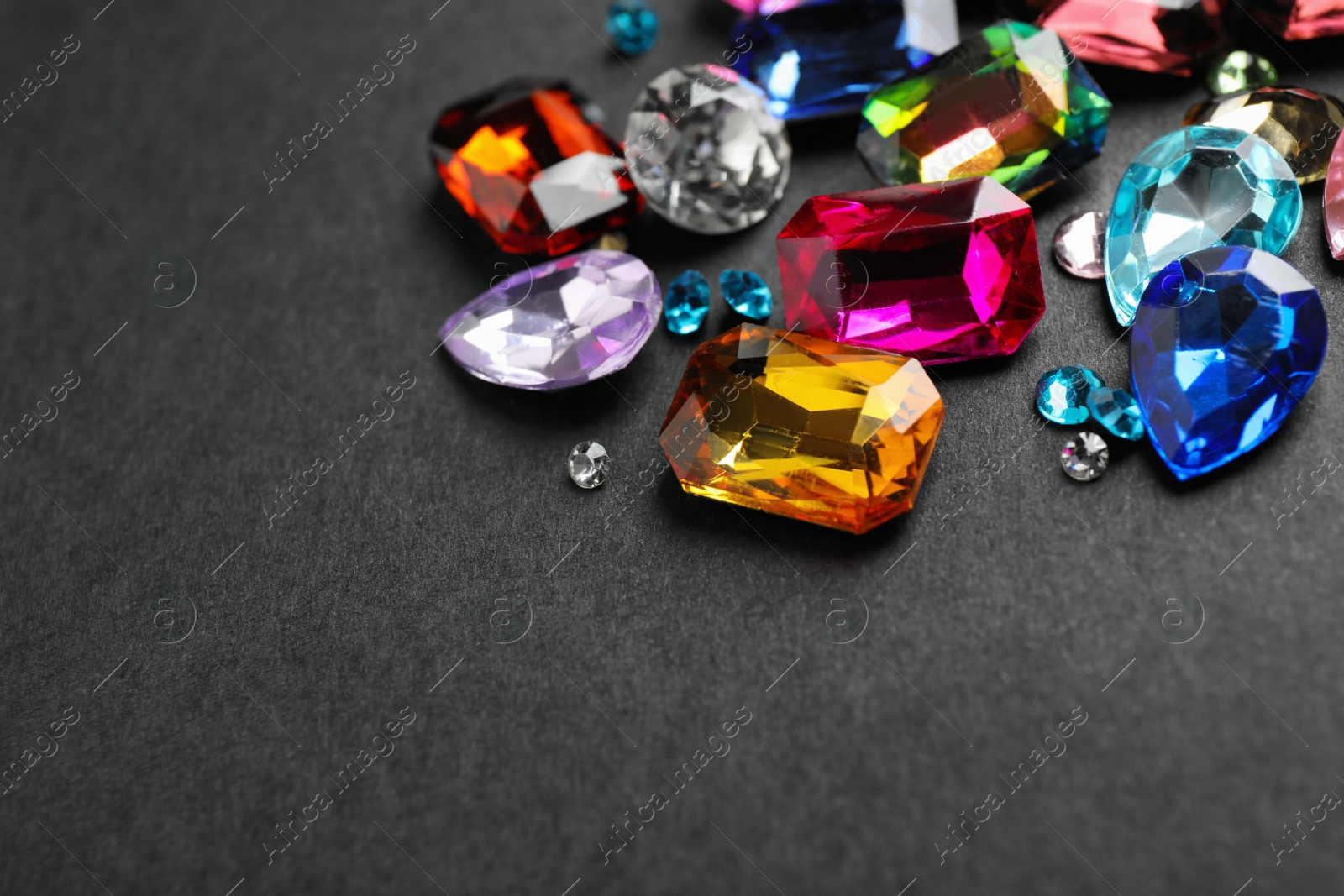 Photo of Different beautiful bright gemstones on black background