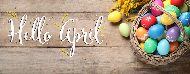 Image of Hello April card. Colorful Easter eggs and mimosa flowers on wooden background, flat lay. Banner design