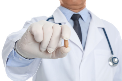 Photo of Doctor holding suppository for hemorrhoid treatment on white background, closeup