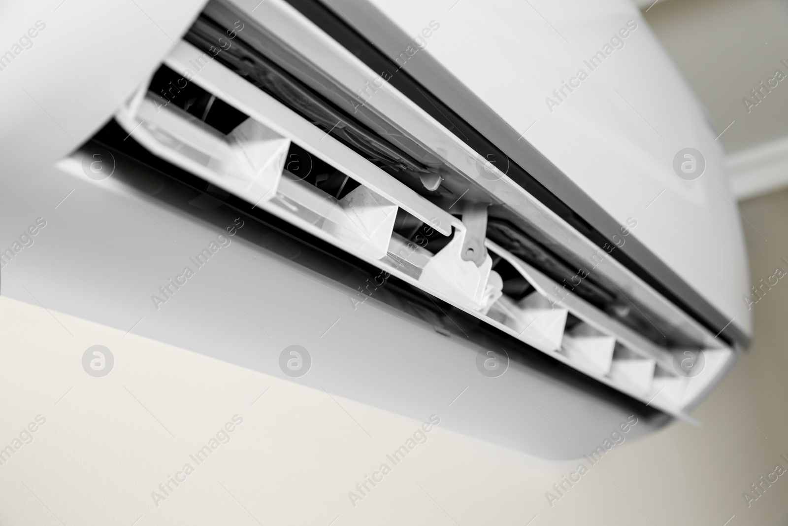 Photo of Modern air conditioner on white wall indoors, closeup view