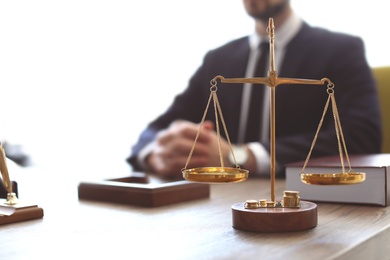 Photo of Scales on table and lawyer in office