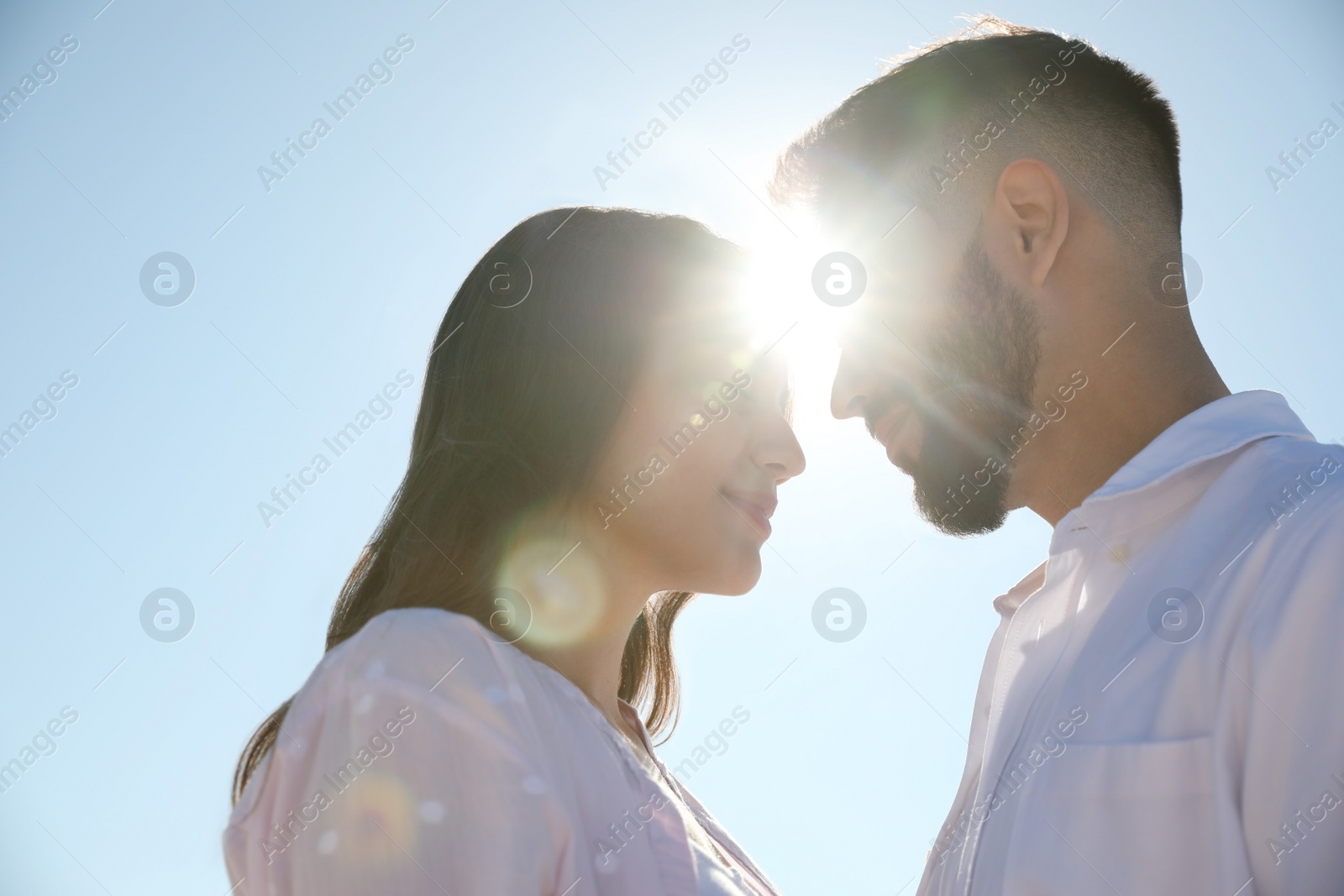 Photo of Happy young couple against blue sky, low angle view. Honeymoon trip