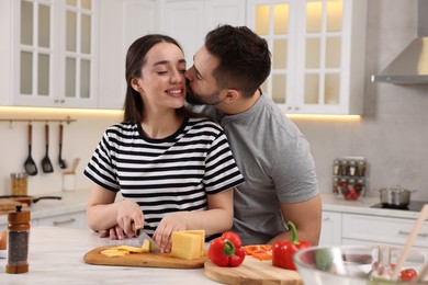 Photo of Lovely young couple cooking together in kitchen