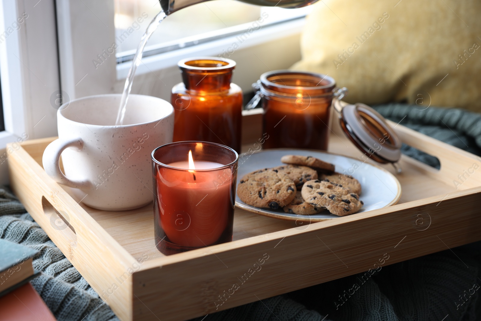 Photo of Breakfast tray with burning candles near window indoors