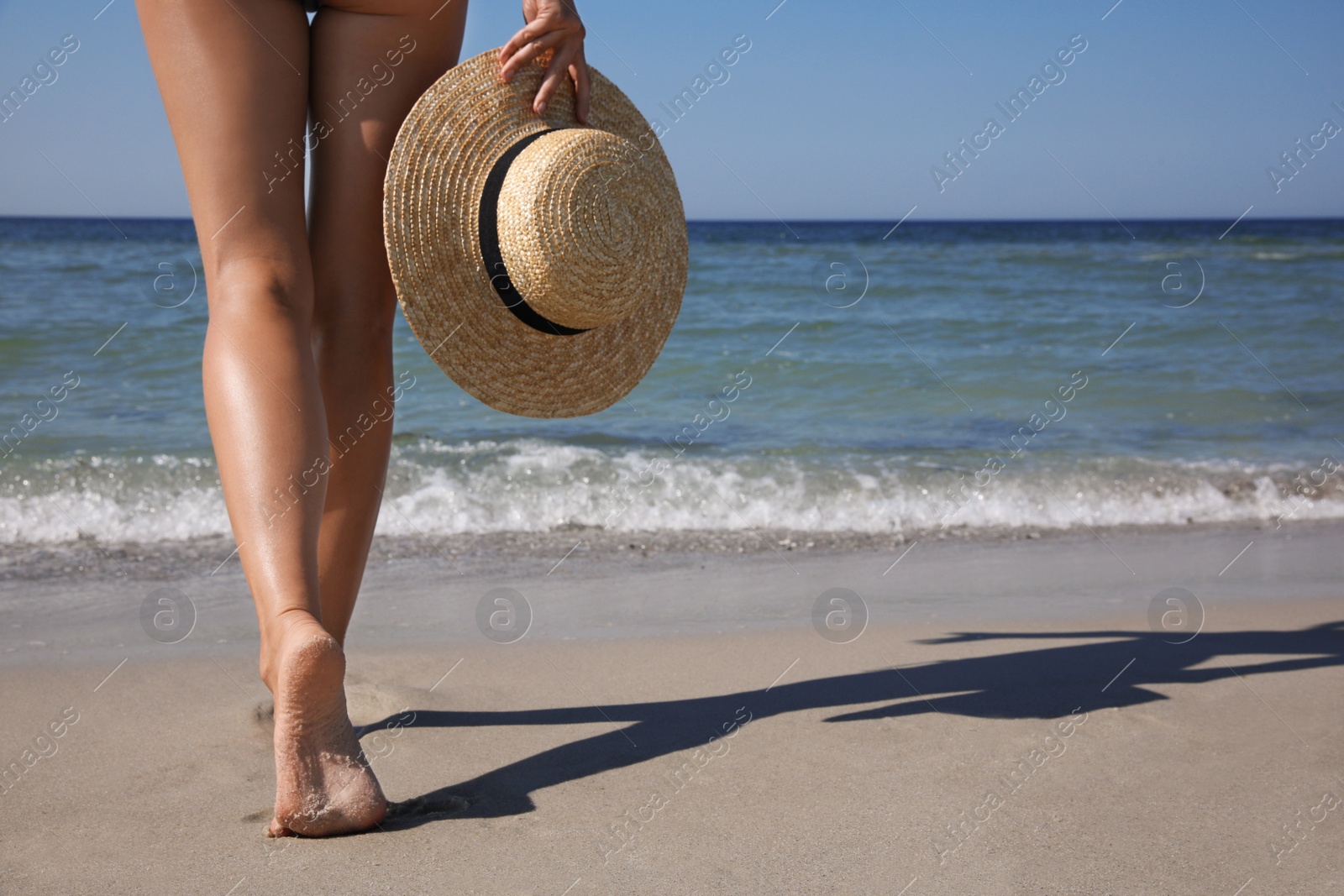 Photo of Woman with hat walking near sea, closeup