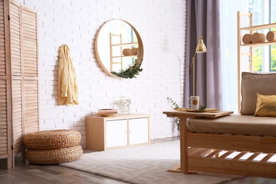 Photo of Elegant room interior with round mirror on brick wall