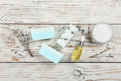 Photo of Flat lay composition with natural handmade soap and ingredients on white wooden table