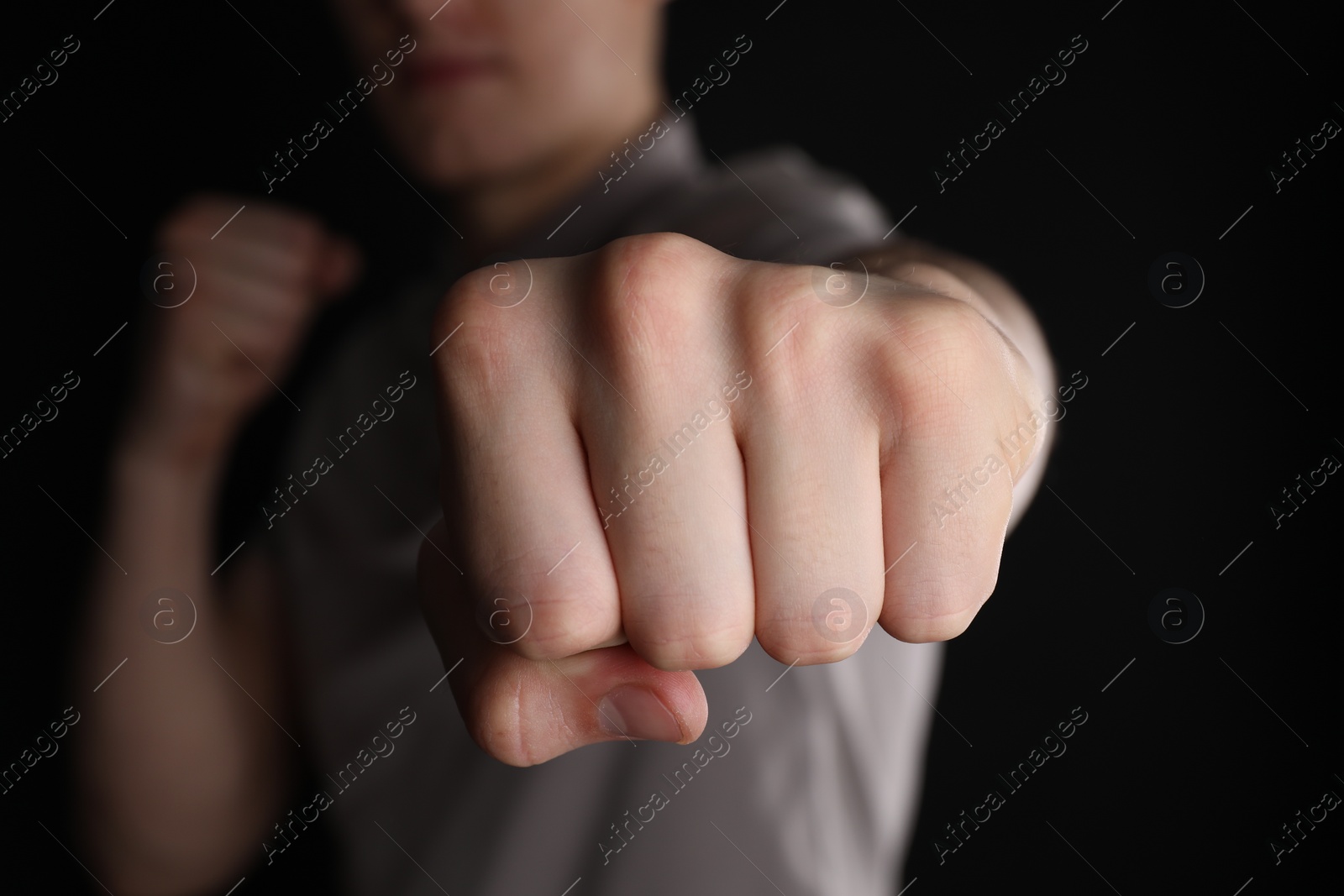 Photo of Man showing fist with space for tattoo on black background, selective focus