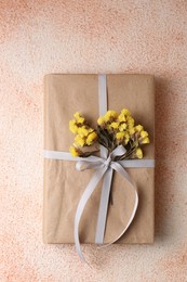 Book decorated with flowers on beige textured background, top view