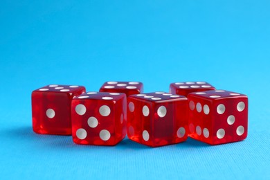 Photo of Many red game dices on light blue background