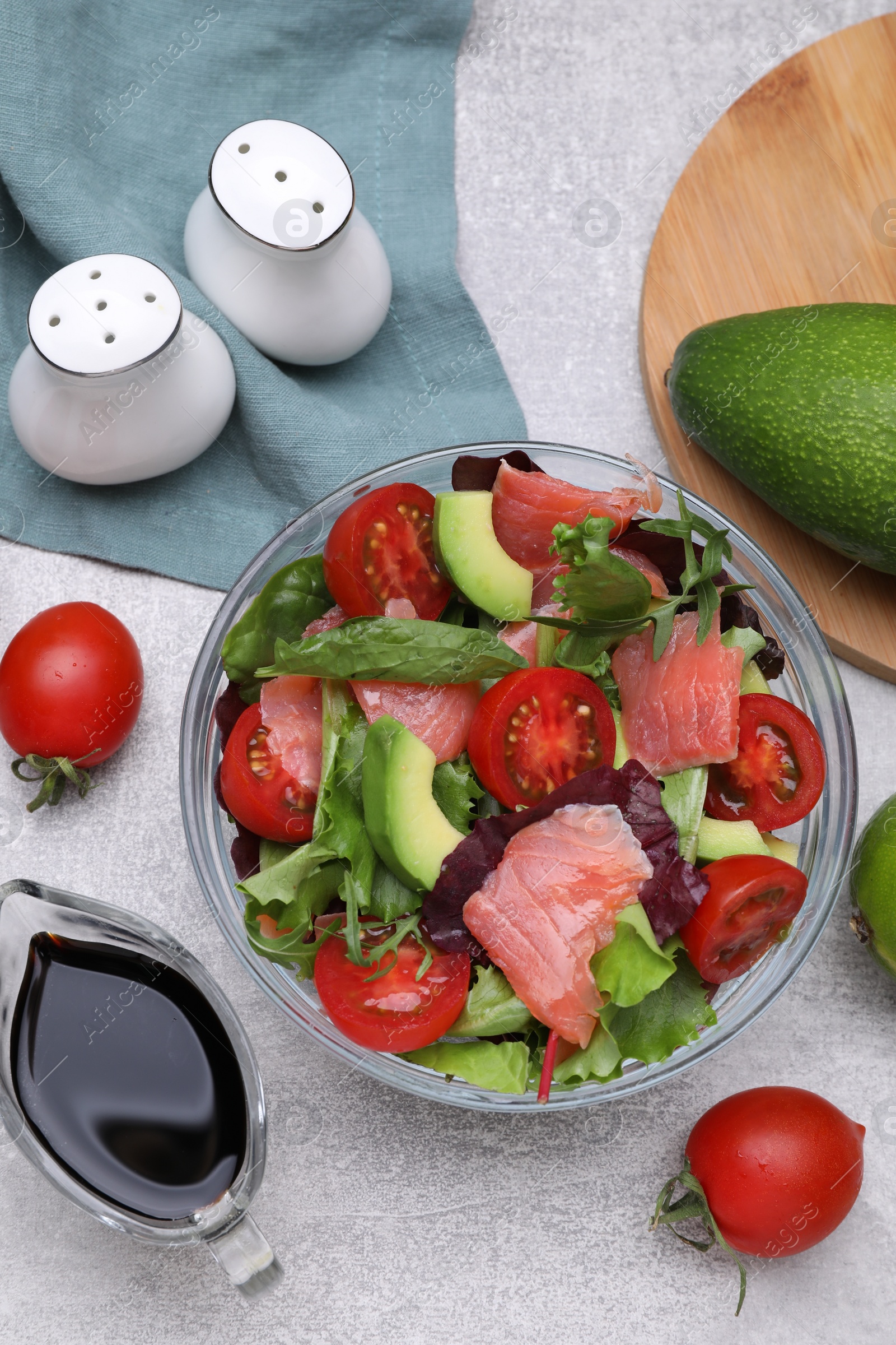 Photo of Soy sauce, salad and ingredients on grey table, flat lay