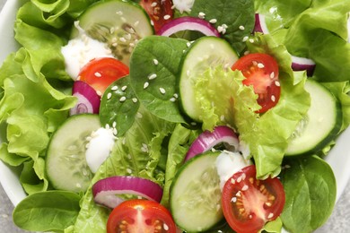 Photo of Delicious salad with cucumbers and tomatoes in bowl, closeup