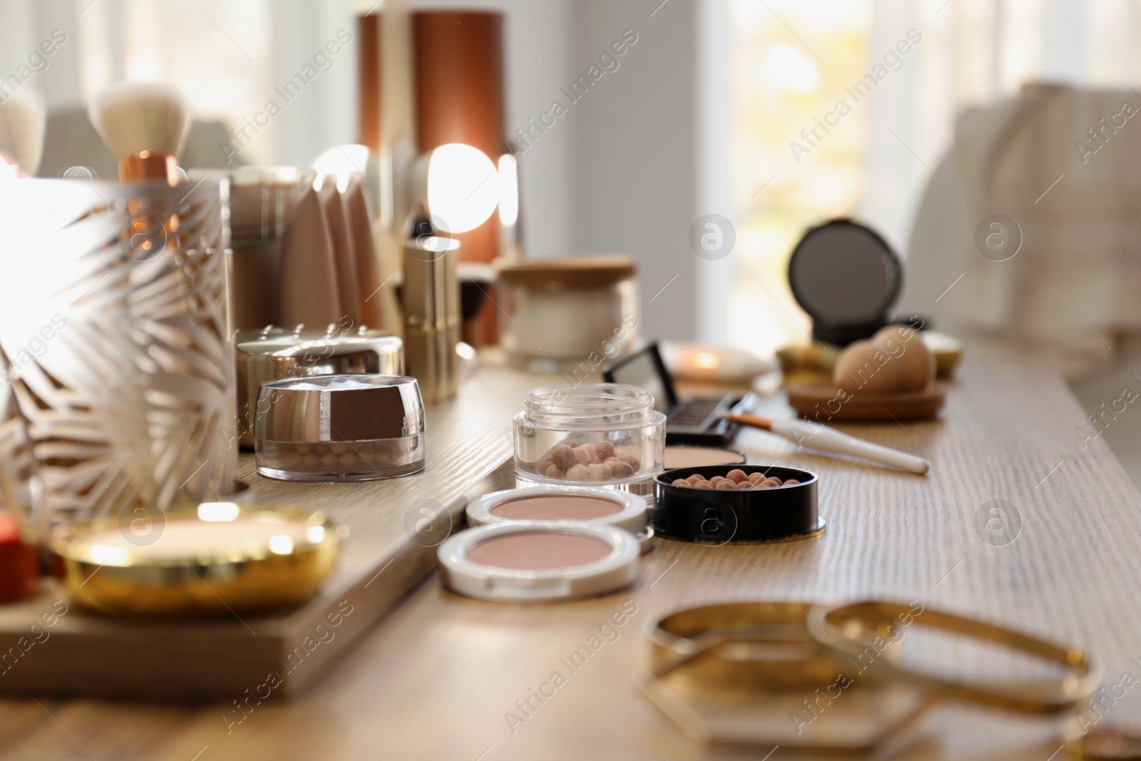 Photo of Many different cosmetic products on dressing table indoors