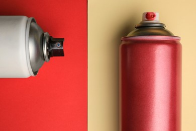 Cans of different graffiti spray paints on color background, flat lay