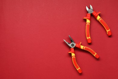 Photo of Pliers on red background, flat lay. Space for text