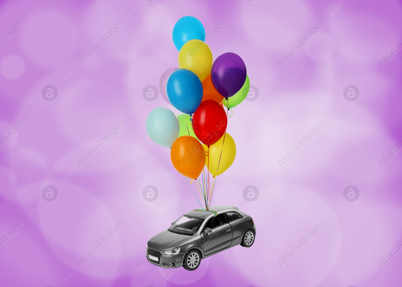 Image of Many balloons tied to toy car flying on magenta background