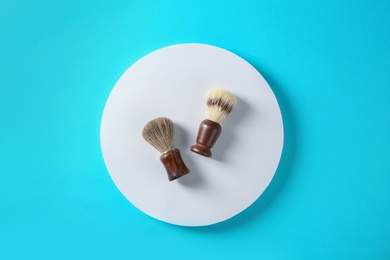 Photo of Flat lay composition with shaving brushes on color background