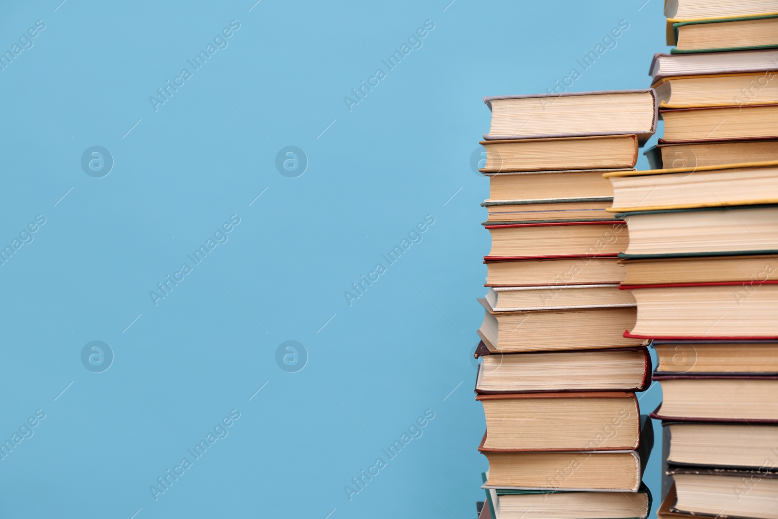 Photo of Many hardcover books on turquoise background, space for text. Library material