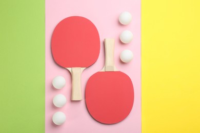 Photo of Ping pong rackets and balls on color background, flat lay