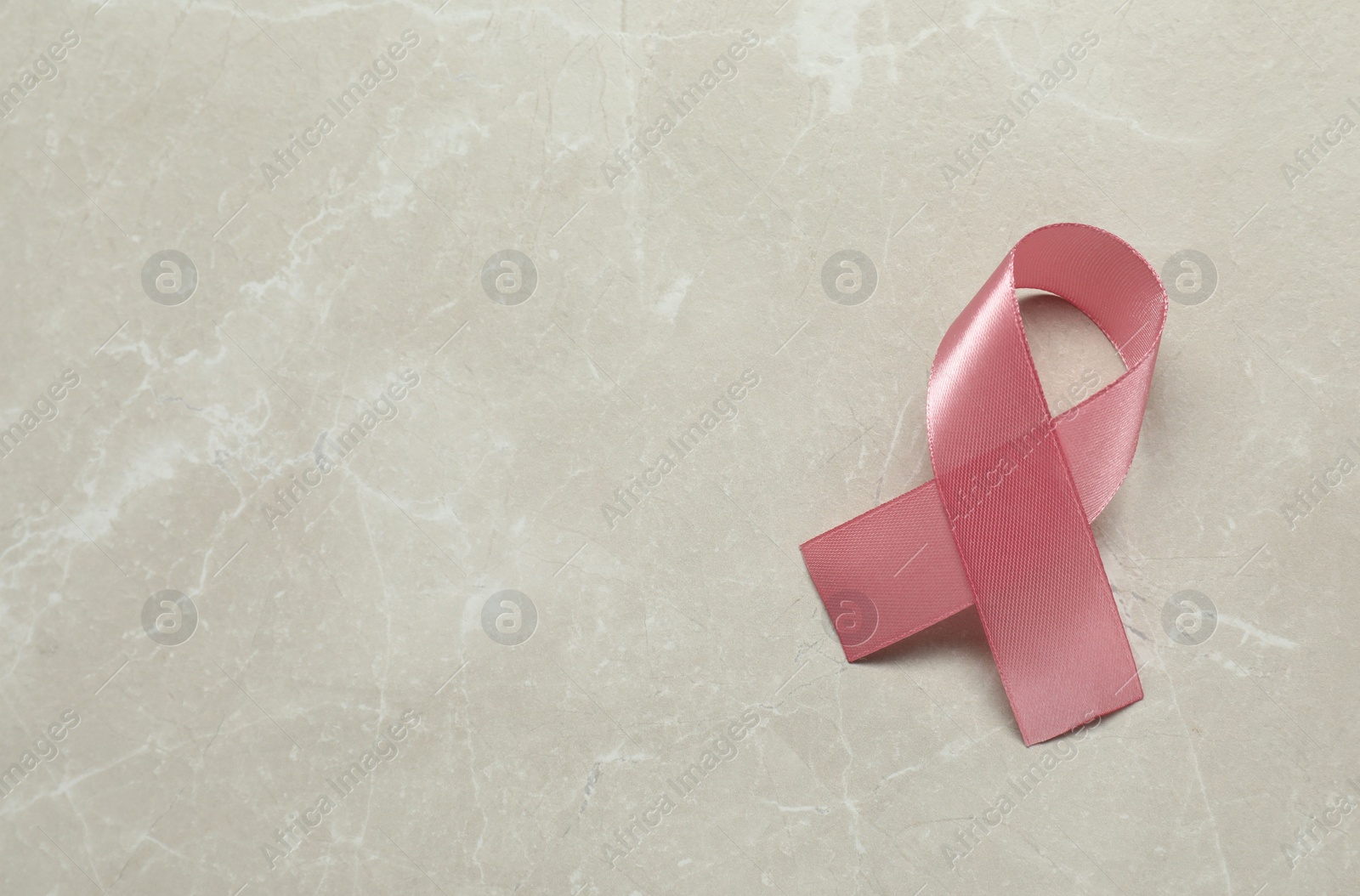 Photo of Breast cancer awareness. Pink ribbon on light grey table, top view. Space for text