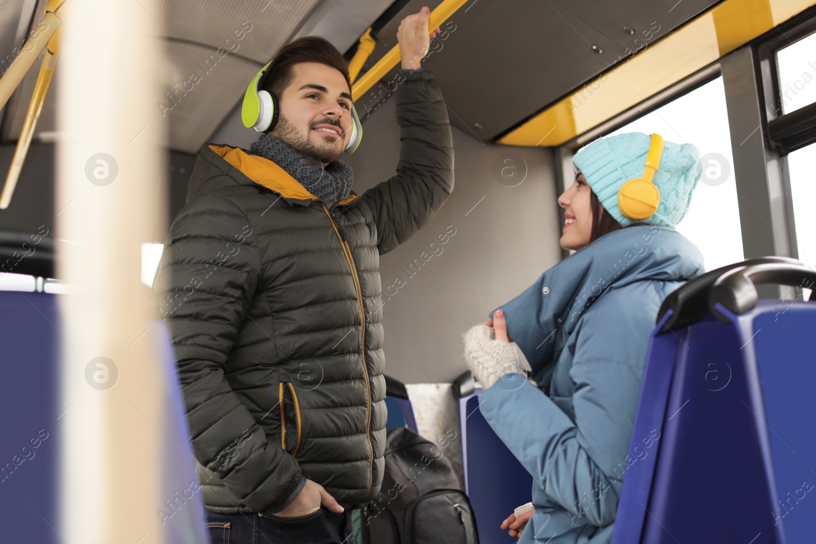 Photo of Young people listening to music with headphones in public transport