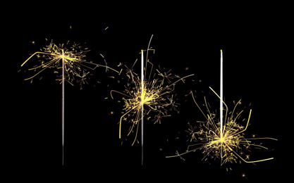 Set of burning sparklers on black background. Party decor