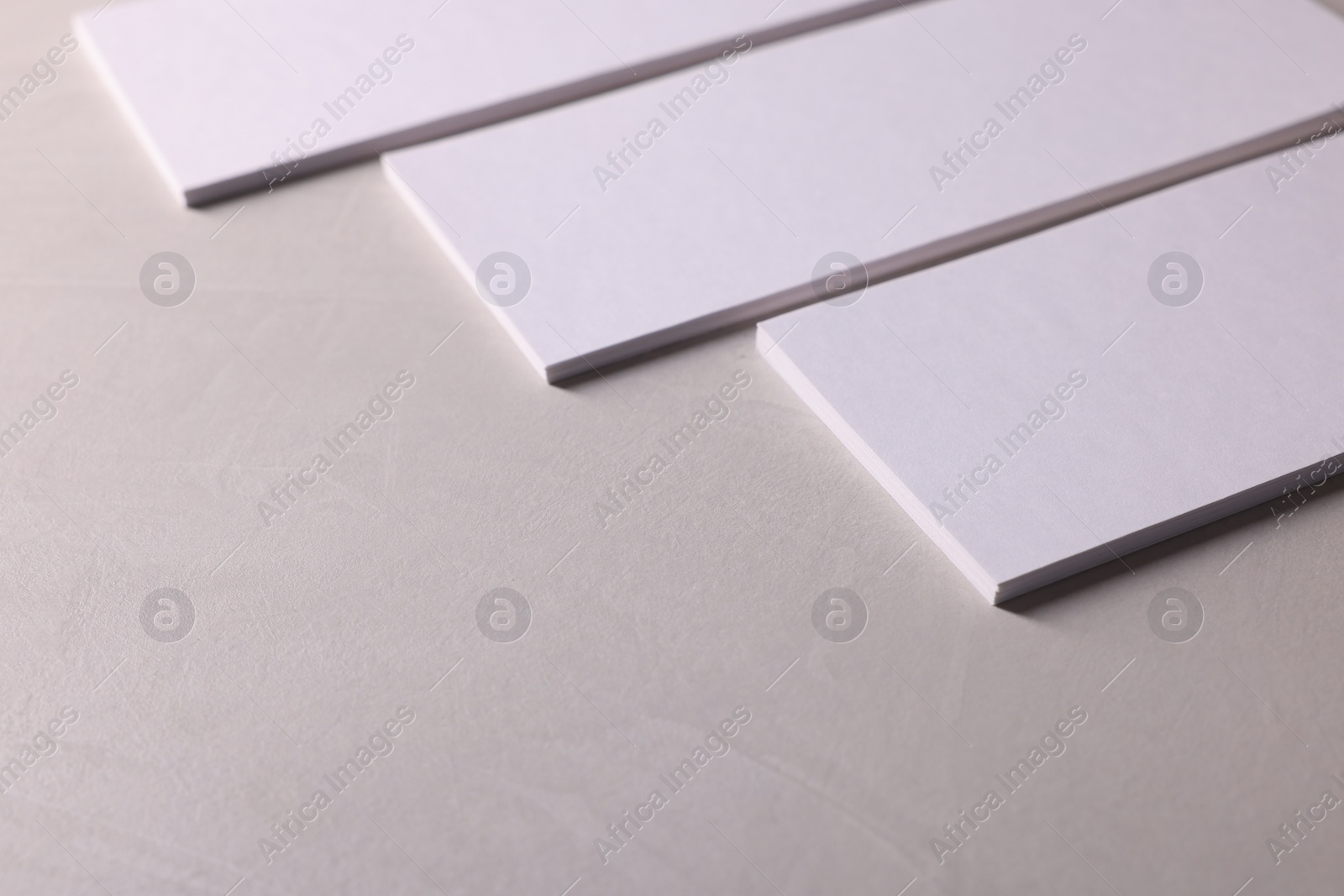 Photo of Blank business cards on light textured table, closeup. Mockup for design