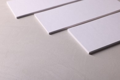 Photo of Blank business cards on light textured table, closeup. Mockup for design