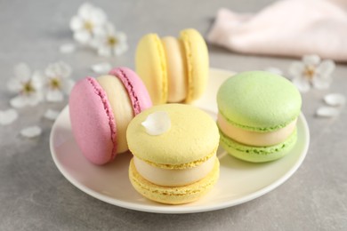 Photo of Delicious colorful macarons on grey table, closeup