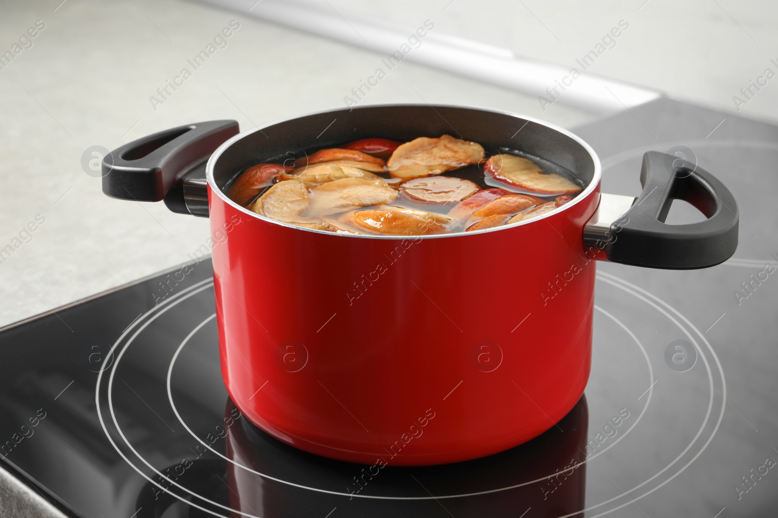 Photo of Pot of delicious compot with dried apple slices on stove