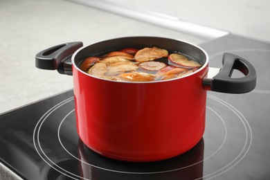 Photo of Pot of delicious compot with dried apple slices on stove