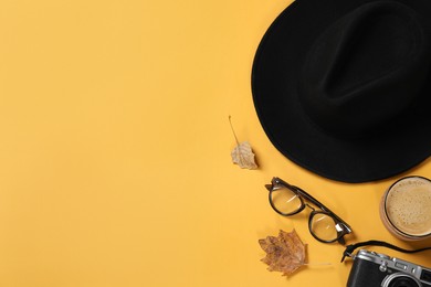 Flat lay composition with stylish hat on yellow background, space for text