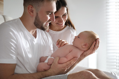 Photo of Happy couple with their newborn baby at home