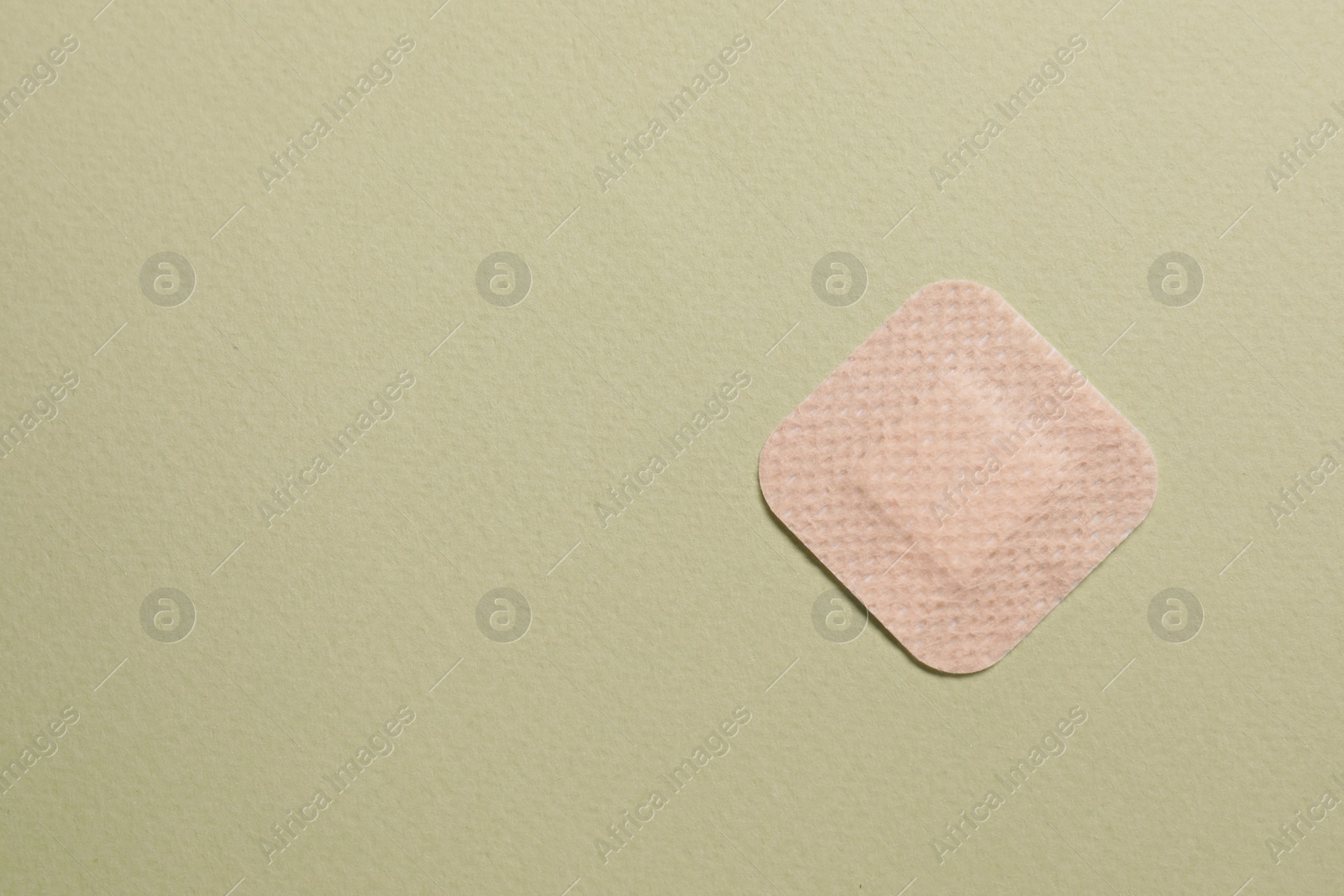 Photo of Contraceptive patch on green background, top view. Space for text