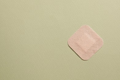 Photo of Contraceptive patch on green background, top view. Space for text