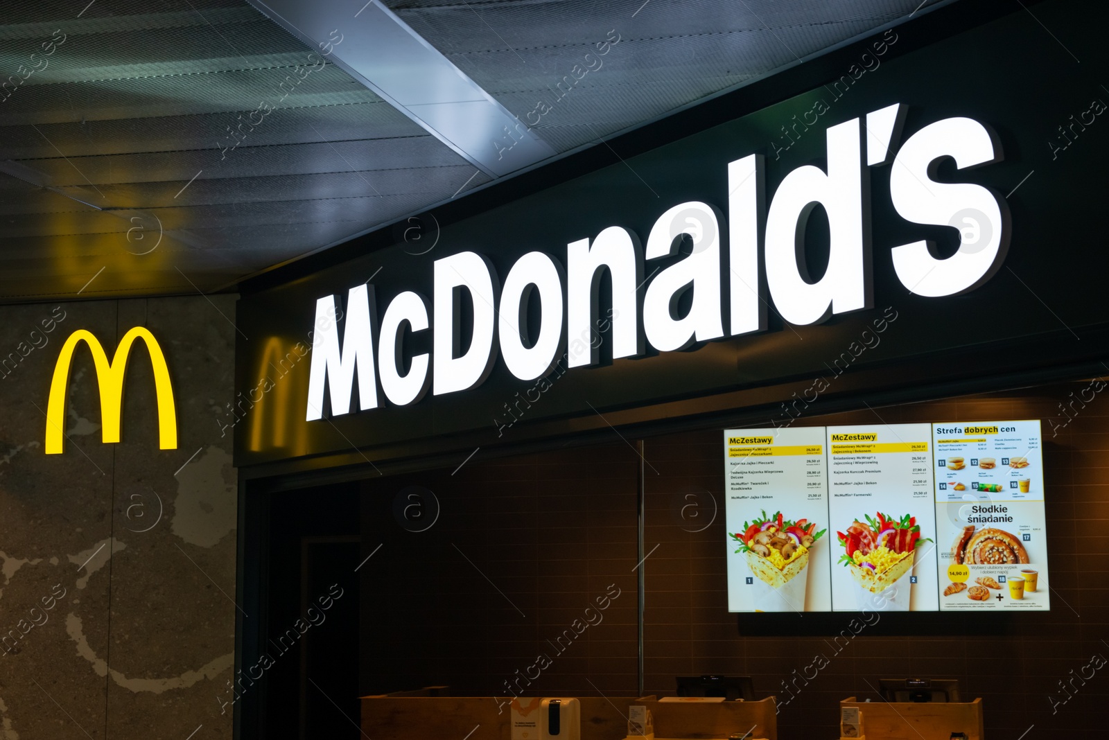 Photo of WARSAW, POLAND - AUGUST 05, 2022: Signboard with McDonald's Restaurant logo and menu indoors