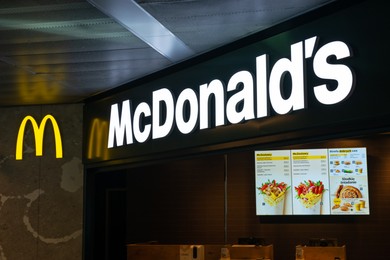 Photo of WARSAW, POLAND - AUGUST 05, 2022: Signboard with McDonald's Restaurant logo and menu indoors