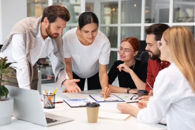 Photo of Team of employees working together in office