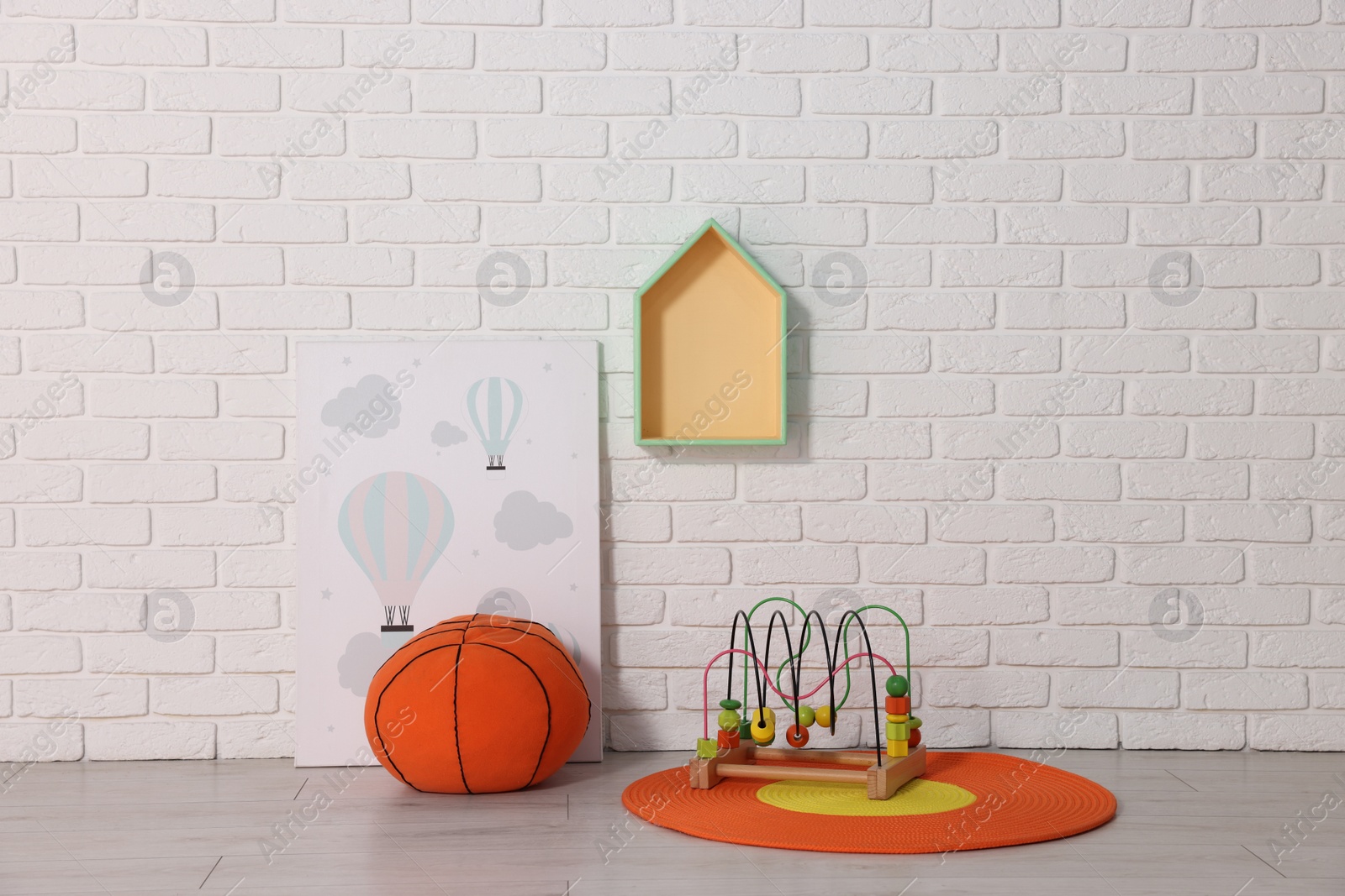 Photo of Beautiful children's room with white brick wall and toys. Interior design