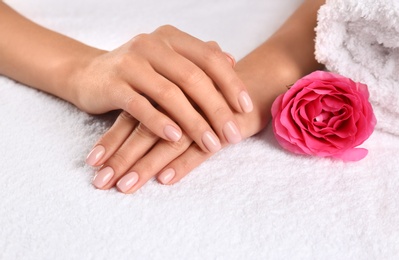 Closeup view of beautiful female hands and rose on towel. Spa treatment