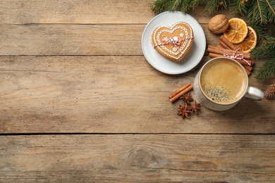 Tasty heart shaped gingerbread cookies, hot drink and Christmas decor on wooden table, flat lay. Space for text