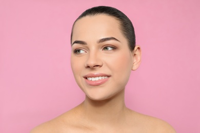 Photo of Portrait of young woman with beautiful face and natural makeup on color background